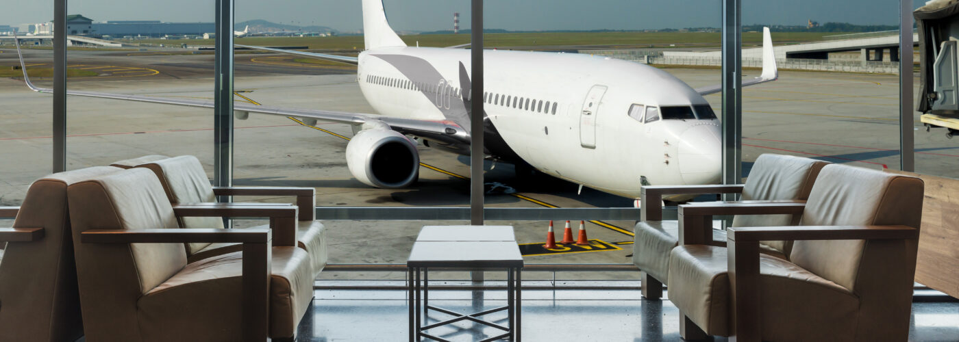 Airport lounge in front of huge window with airplane in background