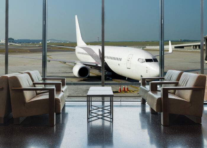 Airport lounge in front of huge window with airplane in background