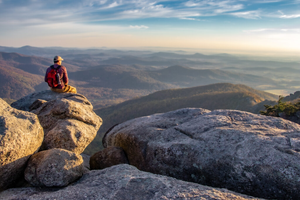 Person sitting on rock and enjoying the views on Old Rag Mountain in Shenandoah National Park