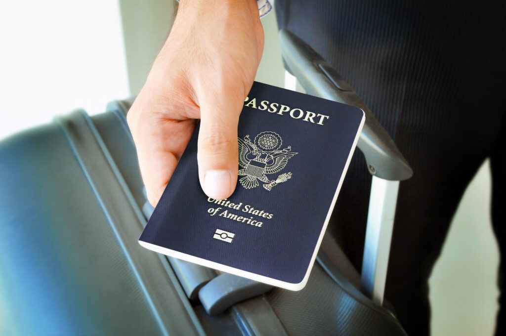 Close up of person holding suitcase and passport